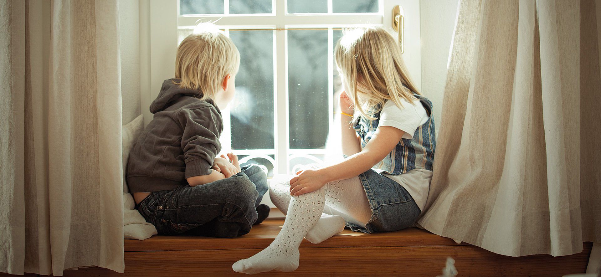 Kinder auf Fensterbank sitzend Kinder auf Fensterbank sitzend
